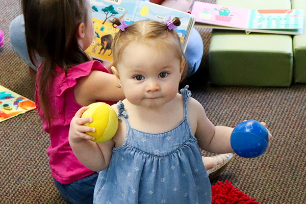 A young child playing with a toy at the counter.